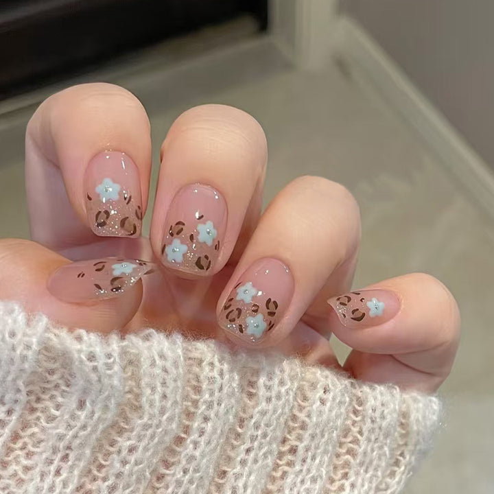 Tattoo of a blooming orchid with leopard print on the nails