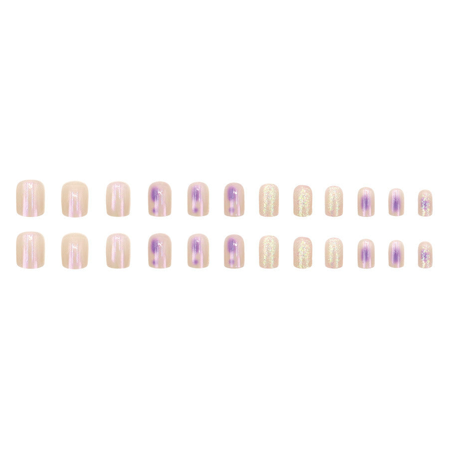 Glitter sprinkled on purple spots for nail decoration