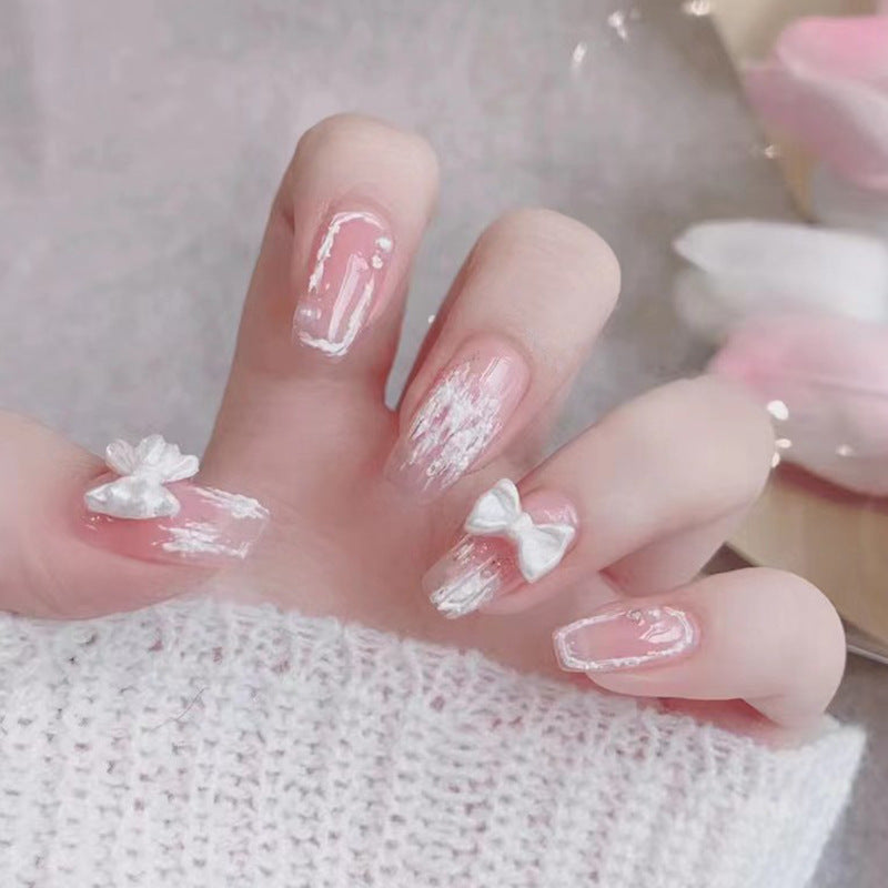 Young girl's pink and white bow-shaped nail polish