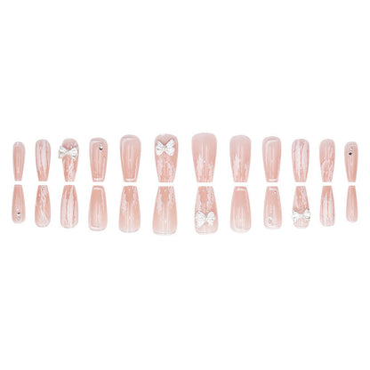 Young girl's pink and white bow-shaped nail polish
