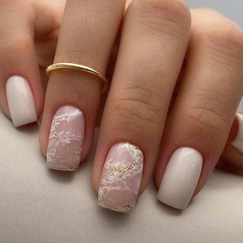 Applying gold foil powder to the nails for a smoky effect