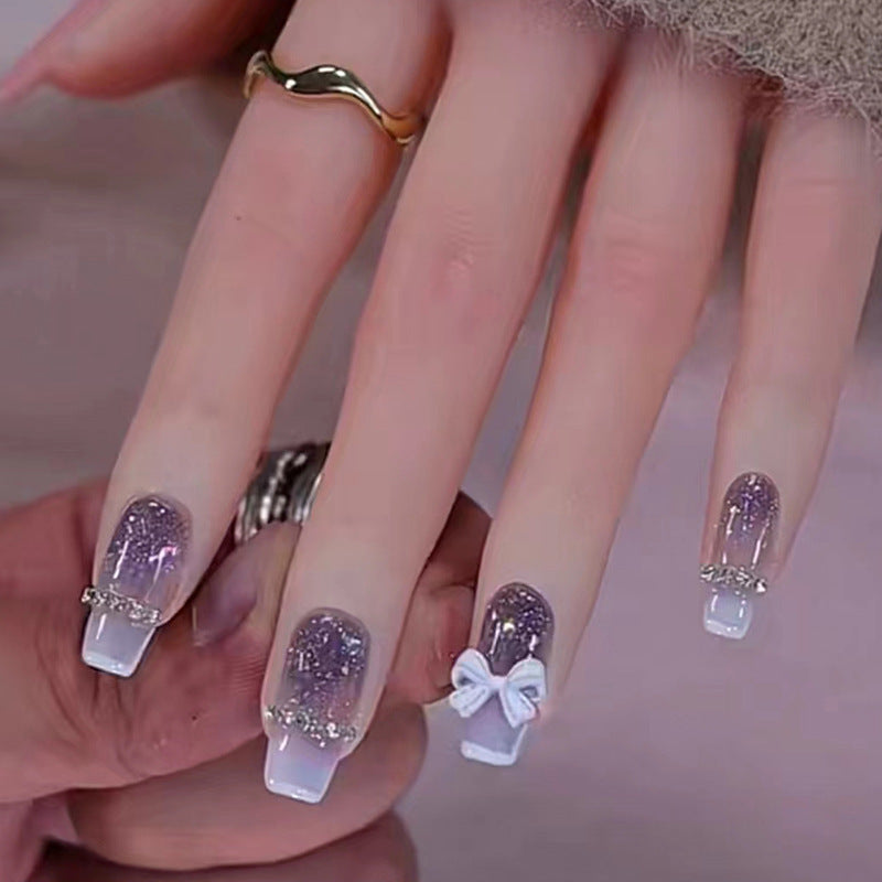 Long-length ballet-style nail chain with diamond-studded bow-shaped embellishment nail art